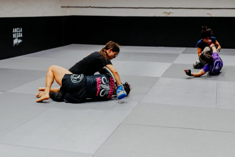 Female martial artists training at a gym in Buenos Aires, showcasing skill and strength.