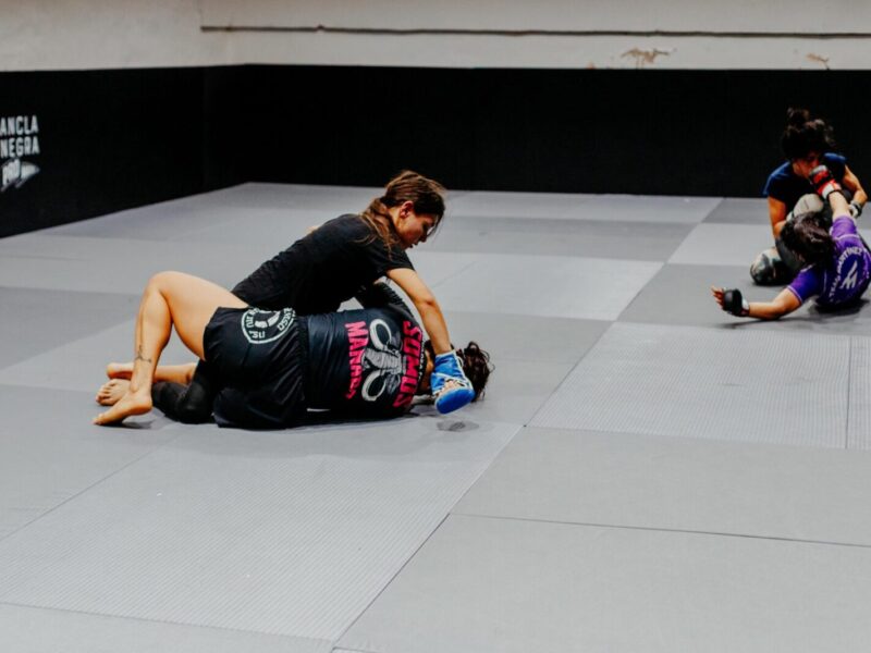 Female martial artists training at a gym in Buenos Aires, showcasing skill and strength.