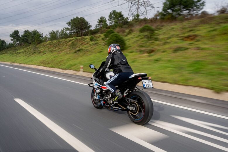 Person riding a motorcycle on a highway, showcasing speed and adventure.